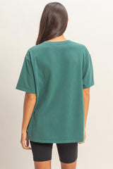 woman wearing a green oversized t-shirt with a relaxed fit and short sleeves, viewed from the back
