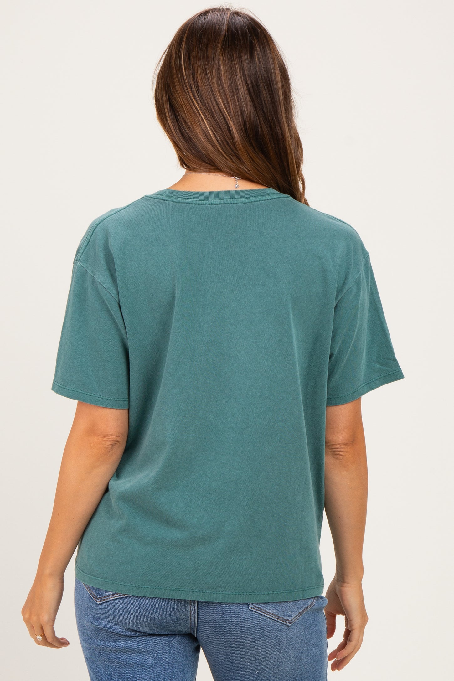woman wearing a teal oversized maternity t-shirt with short sleeves and a relaxed fit