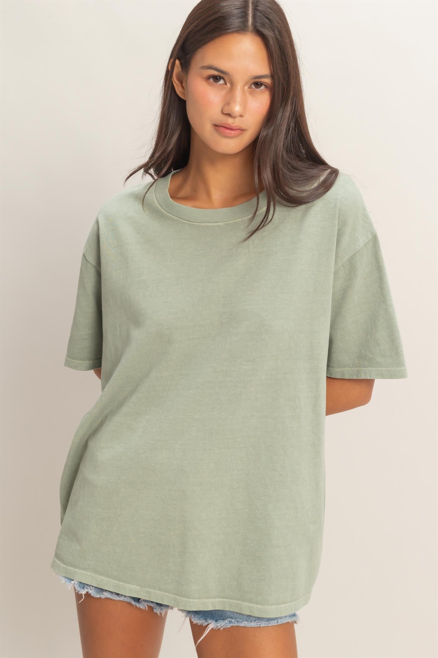 woman wearing a light green oversized t-shirt with short sleeves and a relaxed fit