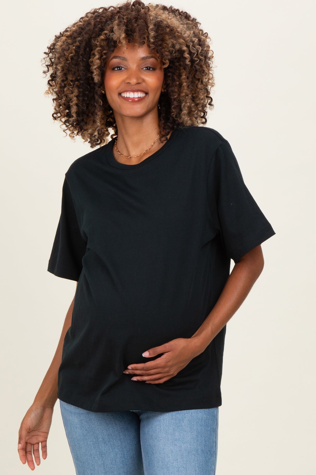 woman wearing a black short sleeve maternity top and holding her baby bump