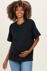woman wearing a black short sleeve maternity top and holding her baby bump