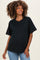 woman wearing a black oversized maternity t-shirt and blue jeans, with a visible baby bump