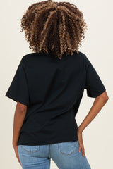 woman wearing a black short sleeve maternity top and blue jeans, showing her back and curly hair