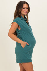 woman wearing a teal maternity polo dress with a baby bump and pockets