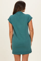 maternity wear in a teal short sleeve dress with a relaxed fit and side button details, model showing back view