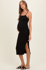 woman wearing a black maternity midi dress with side slits and spaghetti straps, showing her baby bump