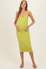 woman wearing a lime green ribbed maternity midi dress and holding her baby bump