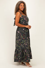 woman wearing a black floral maxi dress with spaghetti straps and a tiered hem