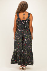 woman wearing a black floral plus size maxi dress with a smocked back and ruffled straps, viewed from the back