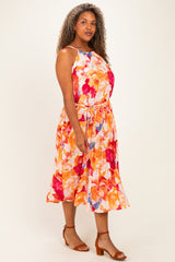 woman wearing a vibrant floral plus-size dress with a cinched waist and flowing skirt