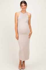 woman wearing a light taupe ribbed maternity dress that accentuates her baby bump