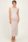 woman wearing a light taupe ribbed maternity dress that accentuates her baby bump