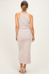 woman wearing a light beige ribbed maternity dress with a fitted silhouette and racerback style, showing a baby bump from the back