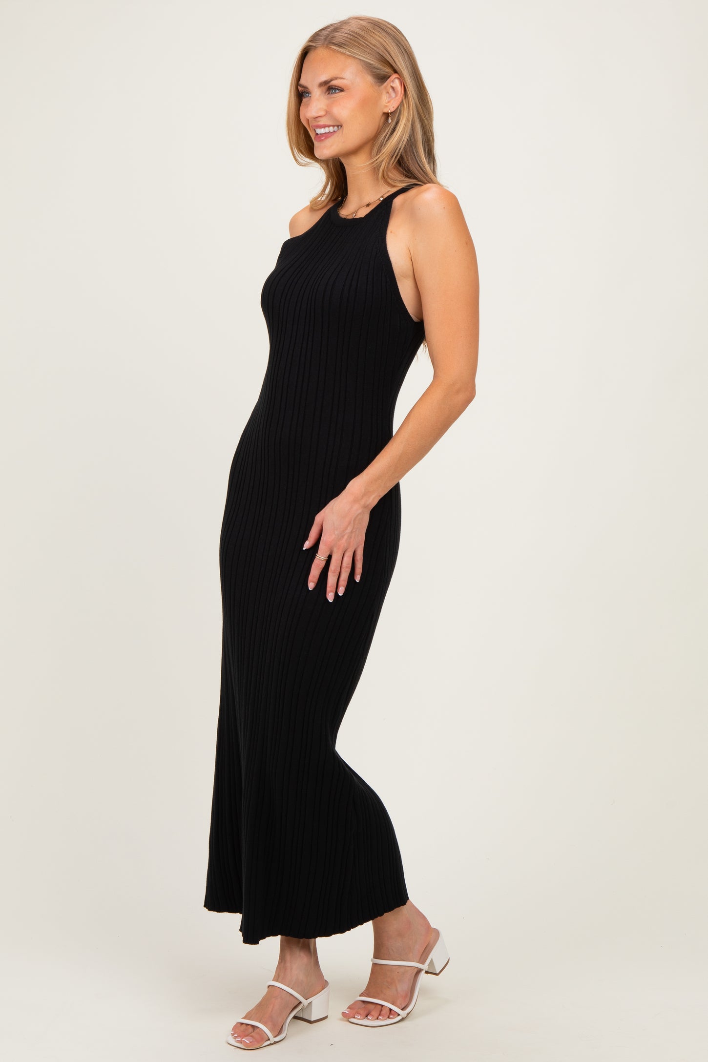 woman wearing a black ribbed maxi dress with a halter neck and a fitted silhouette