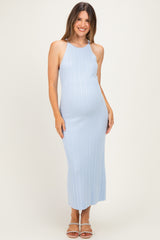 woman wearing a light blue ribbed maternity dress, showcasing her baby bump and styled with straps and a fitted silhouette