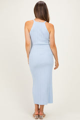 woman wearing a light blue ribbed maternity dress with a fitted silhouette and back cutout detail