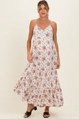woman wearing a white floral maternity maxi dress with a tiered skirt and adjustable straps, highlighting her baby bump