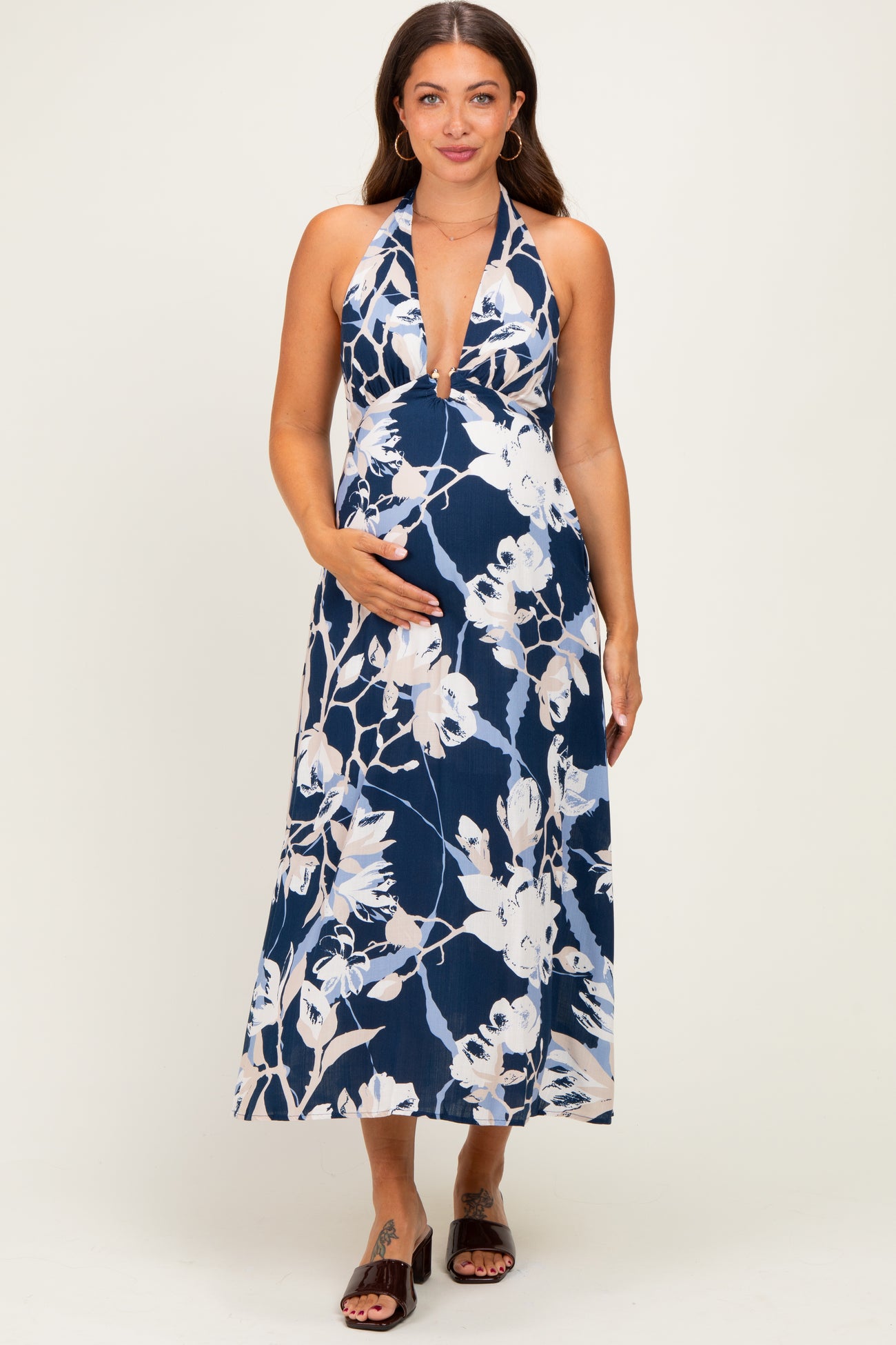 woman wearing a navy floral maternity maxi dress and holding her baby bump
