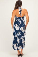 woman wearing a navy floral maternity maxi dress with a halter neckline and smocked back, showing a baby bump