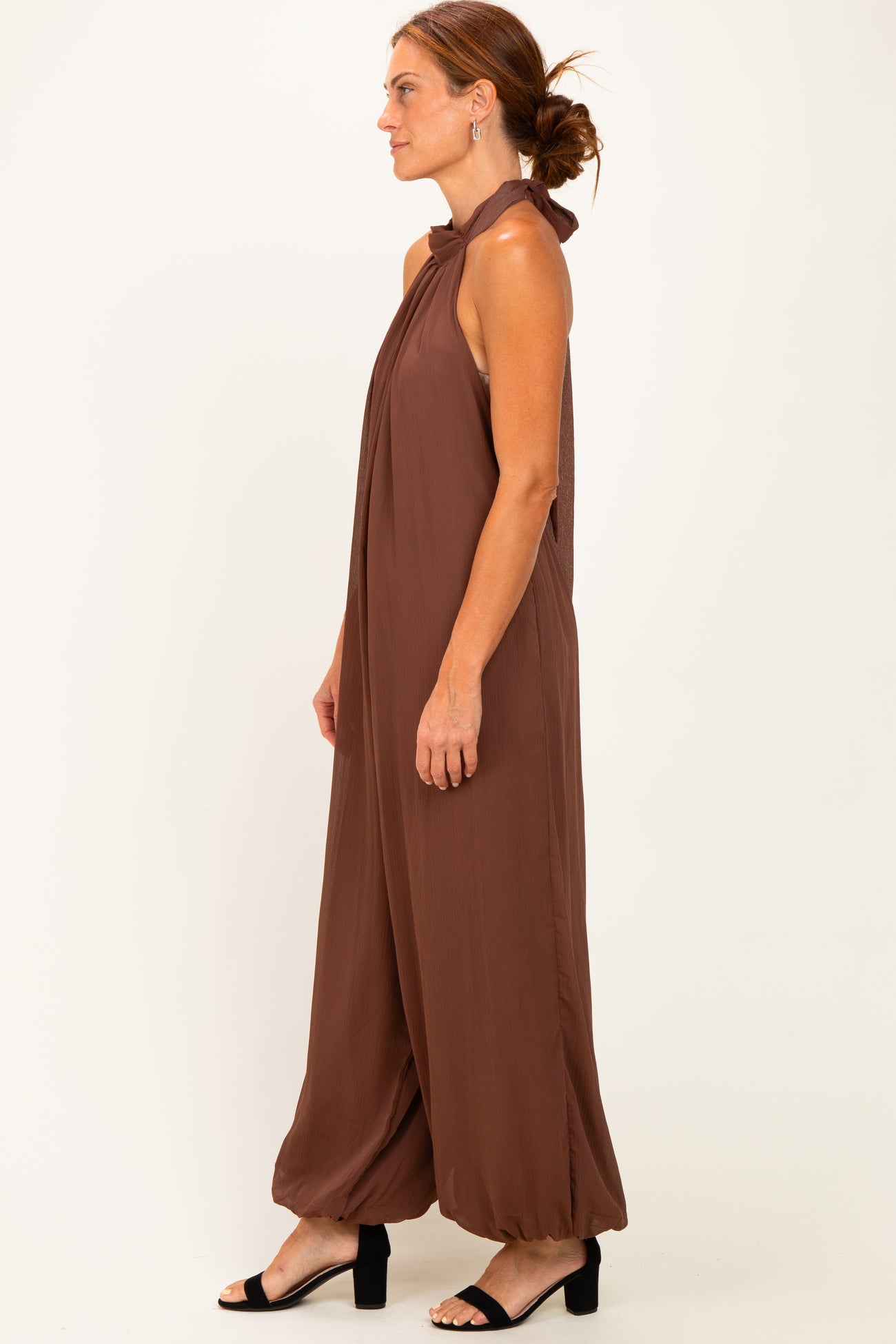 woman wearing a brown halter neck jumpsuit with wide legs and a relaxed fit