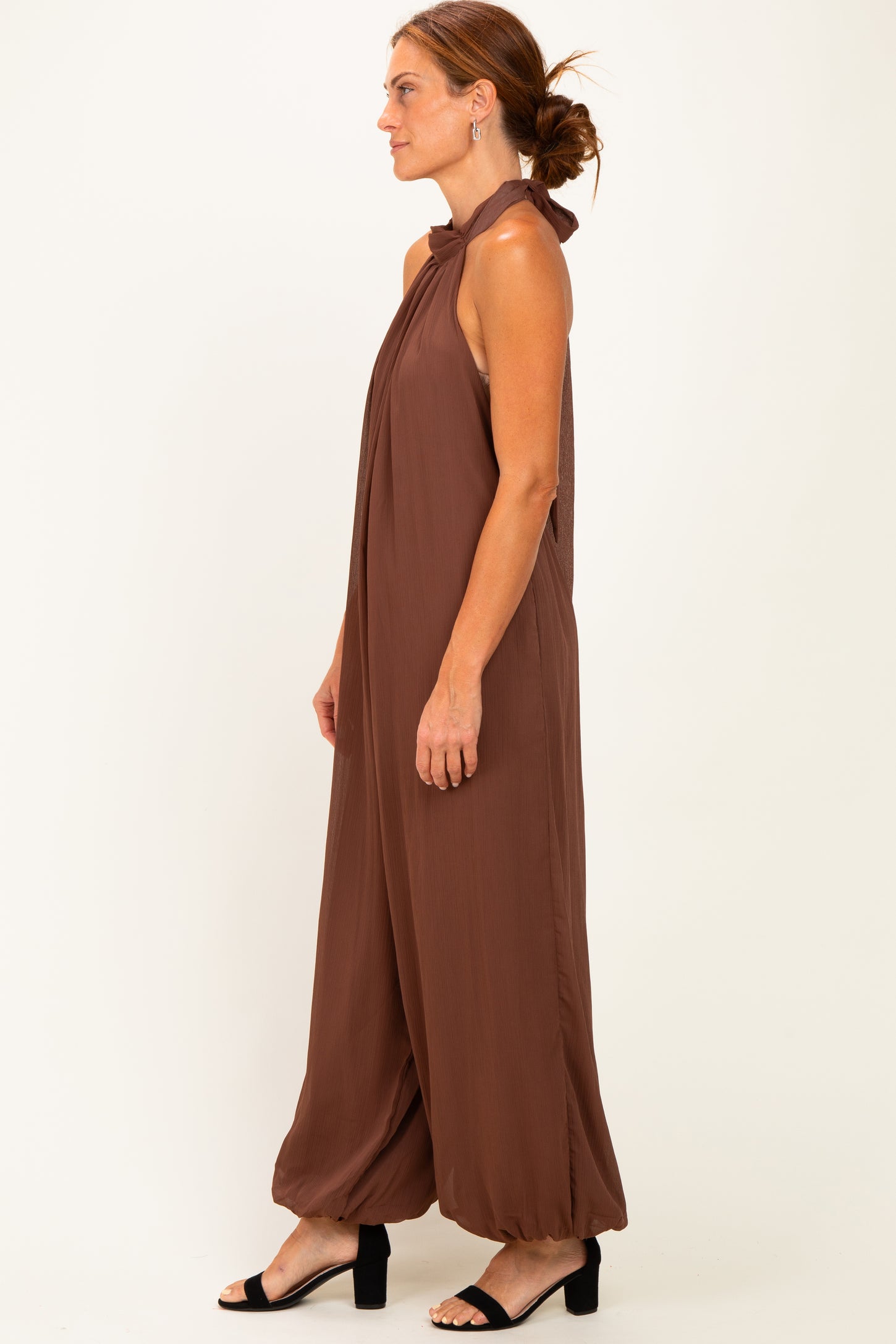woman wearing a brown halter neck jumpsuit with wide legs and a relaxed fit