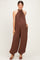woman wearing a brown halter neck maternity jumpsuit with a baby bump and loose, flowing pants