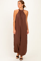 woman wearing a brown halter neck maxi dress with a flowy silhouette and loose fit