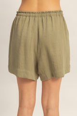 woman wearing olive green relaxed fit shorts with an elastic waistband and curved hemline