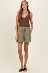 woman wearing a brown ribbed tank top and green maternity shorts with pockets