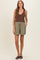 woman wearing a brown ribbed tank top and green maternity shorts with pockets
