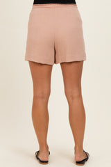woman wearing light pink maternity shorts, showing the back view with a relaxed fit and rolled hem