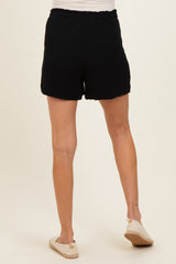 woman wearing black maternity shorts, showing the back view, paired with casual shoes