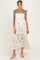 woman wearing a floral maternity maxi dress with ruffle tiers and tie straps, showcasing her baby bump