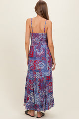 woman wearing a blue and purple patterned maternity maxi dress with spaghetti straps and a flowy hemline