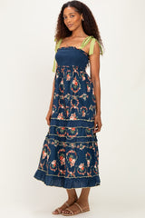 woman wearing a navy floral maxi dress with smocked bodice and green tie straps