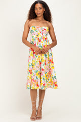 woman wearing a floral strapless midi dress with a tie front detail and a flared skirt