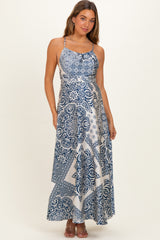 woman wearing a navy and white patterned maternity maxi dress with spaghetti straps and a flowing skirt, baby bump visible