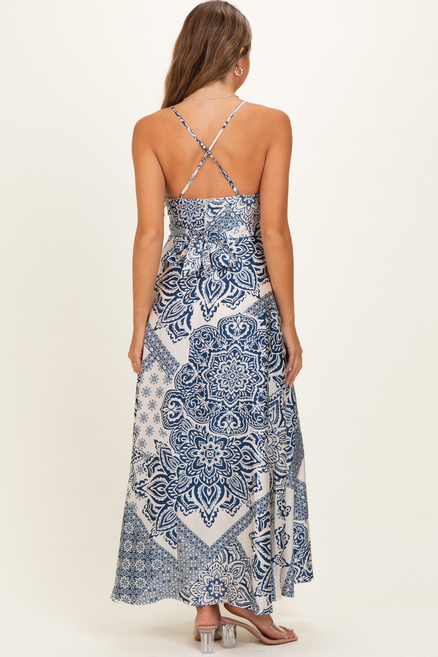 woman wearing a blue and white patterned maternity maxi dress with a crisscross back design