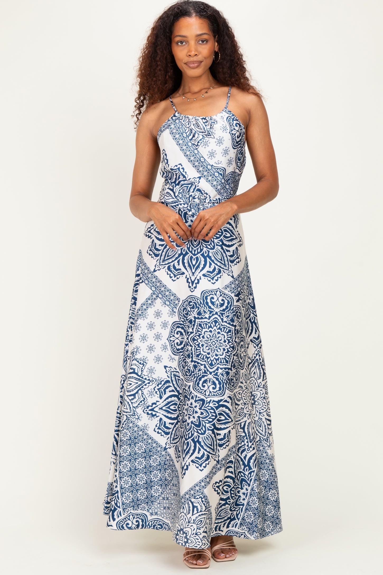 woman wearing a blue and white patterned maxi dress with spaghetti straps