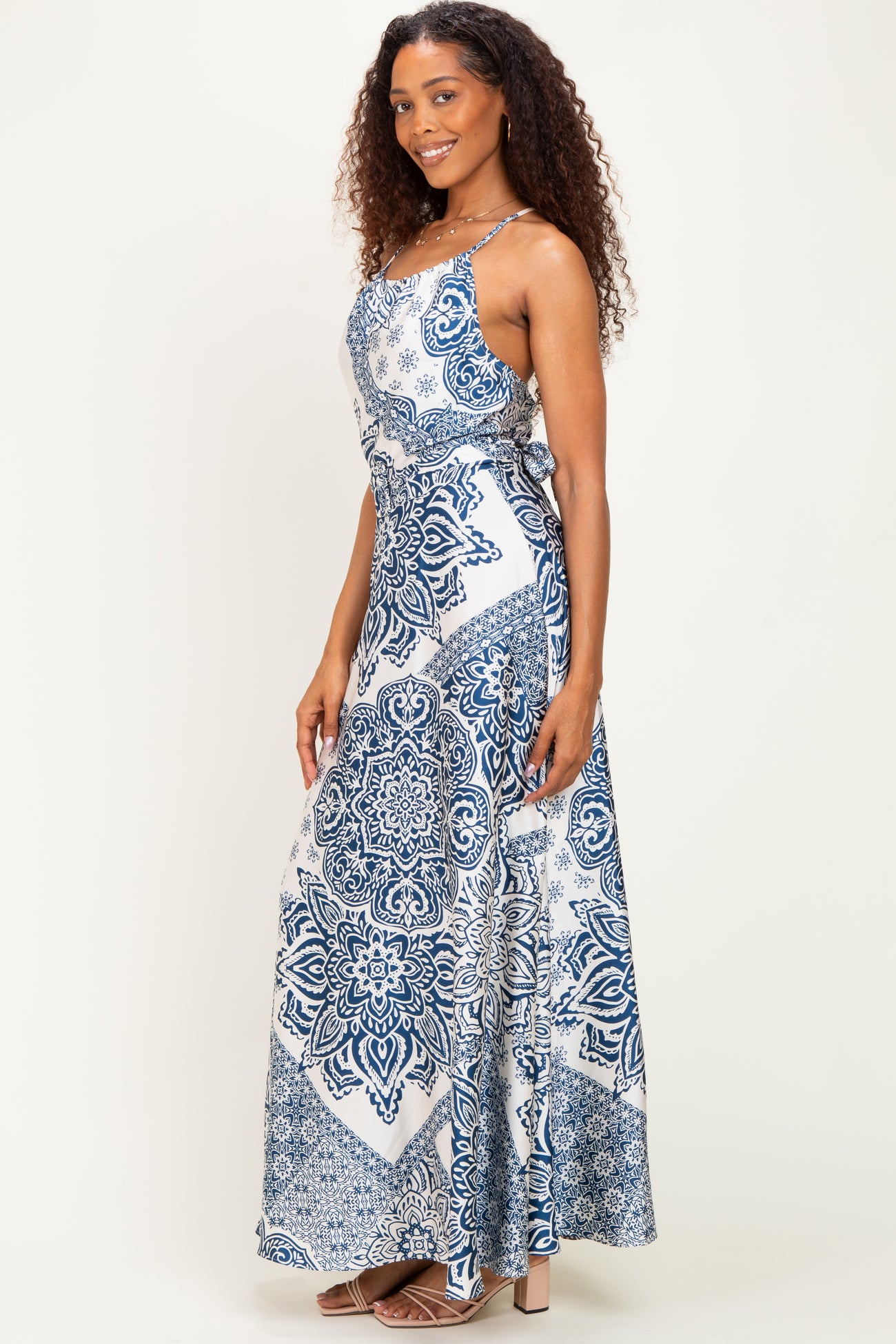 woman wearing a navy and white patterned maxi dress with adjustable straps and a flowing silhouette