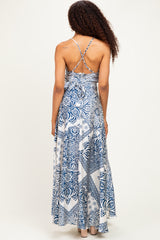 woman wearing a blue and white floral maxi dress with a crisscross back design