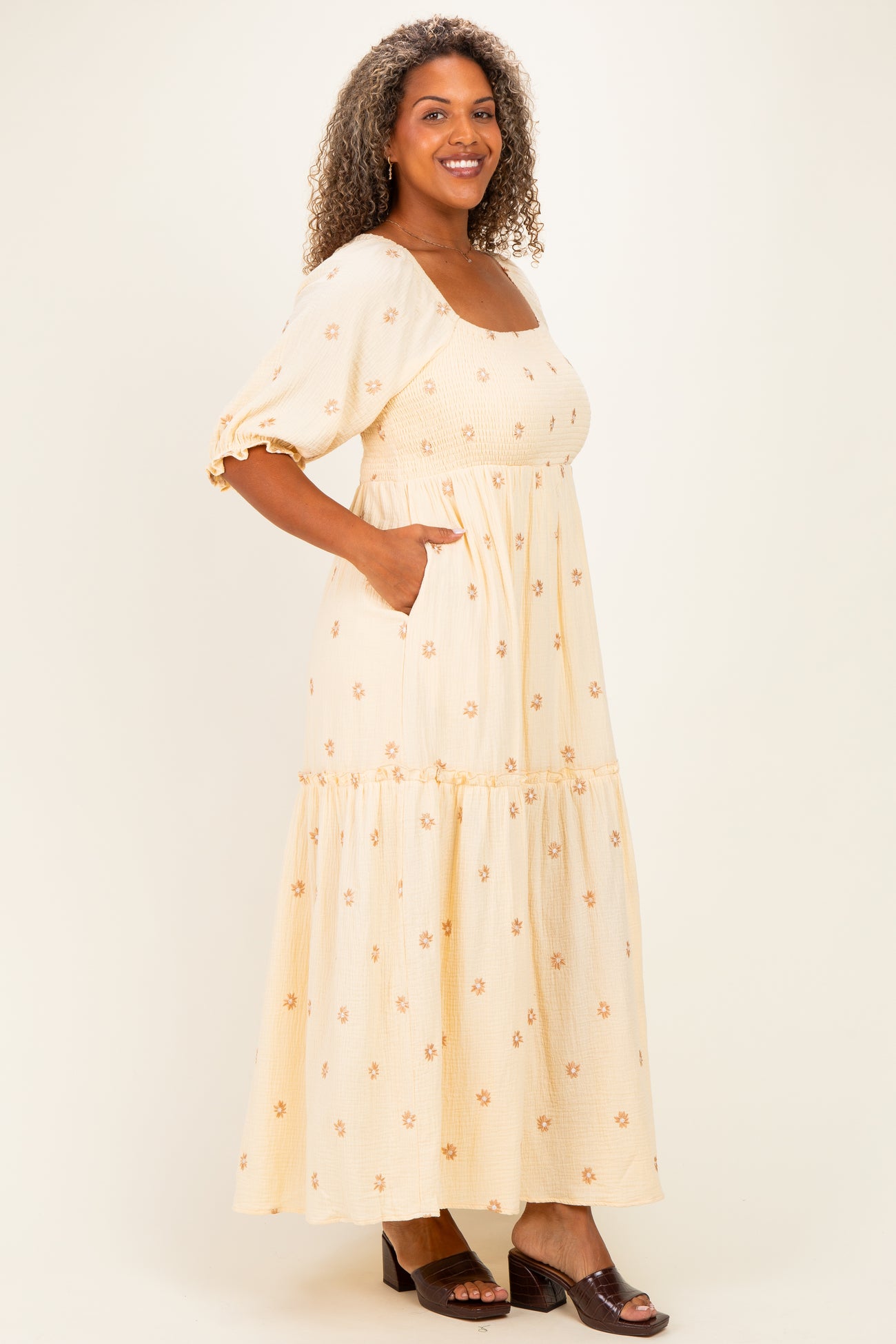 woman wearing a yellow floral plus size maxi dress with puff sleeves and pockets