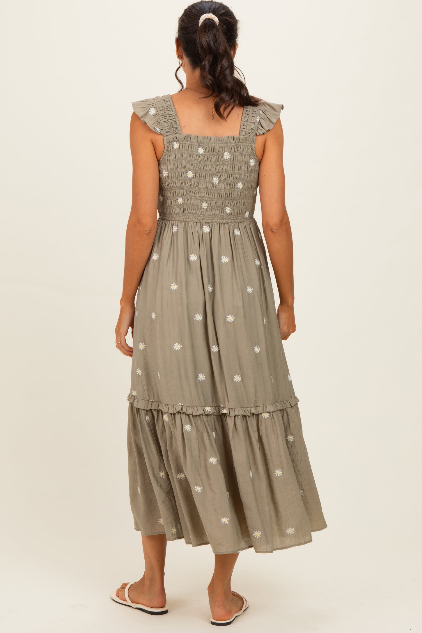 woman wearing a green floral maxi dress with ruffled straps and a smocked bodice, shown from the back