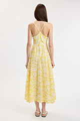 woman wearing a yellow floral midi dress with spaghetti straps, showing the back view