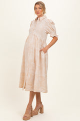 woman wearing a light peach paisley print maternity dress with short puff sleeves and a button-down front, baby bump visible