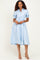 woman wearing a light blue paisley print button-up midi dress with short puff sleeves and a cinched waist