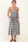 woman wearing a strapless midi dress with a gray and white plaid pattern and side pockets