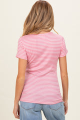 woman wearing a pink striped maternity top, viewed from the back, paired with light blue jeans