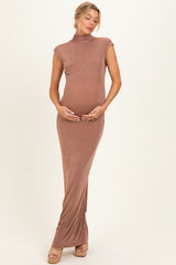 woman wearing a brown sleeveless maternity dress with a mock neck and baby bump visible
