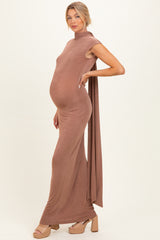 woman wearing a brown maternity maxi dress with a high neckline and draped fabric, showing her baby bump